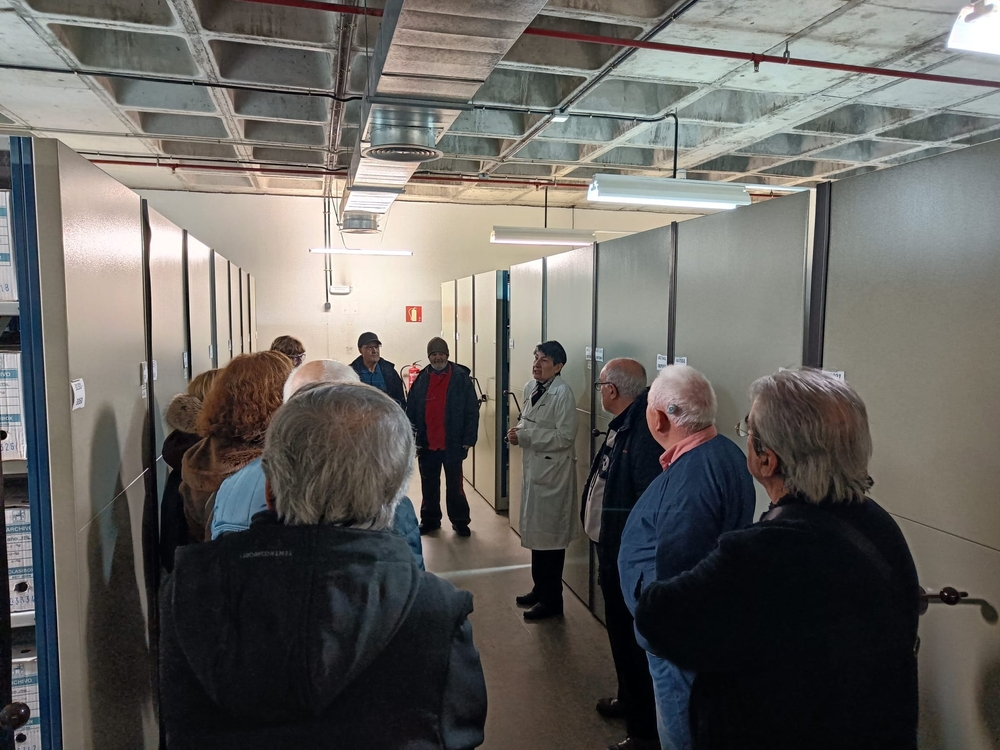 Grupo de visitantes mayores en una sala del Archivo Municipal de Fuenlabrada durante una visita guiada temática
